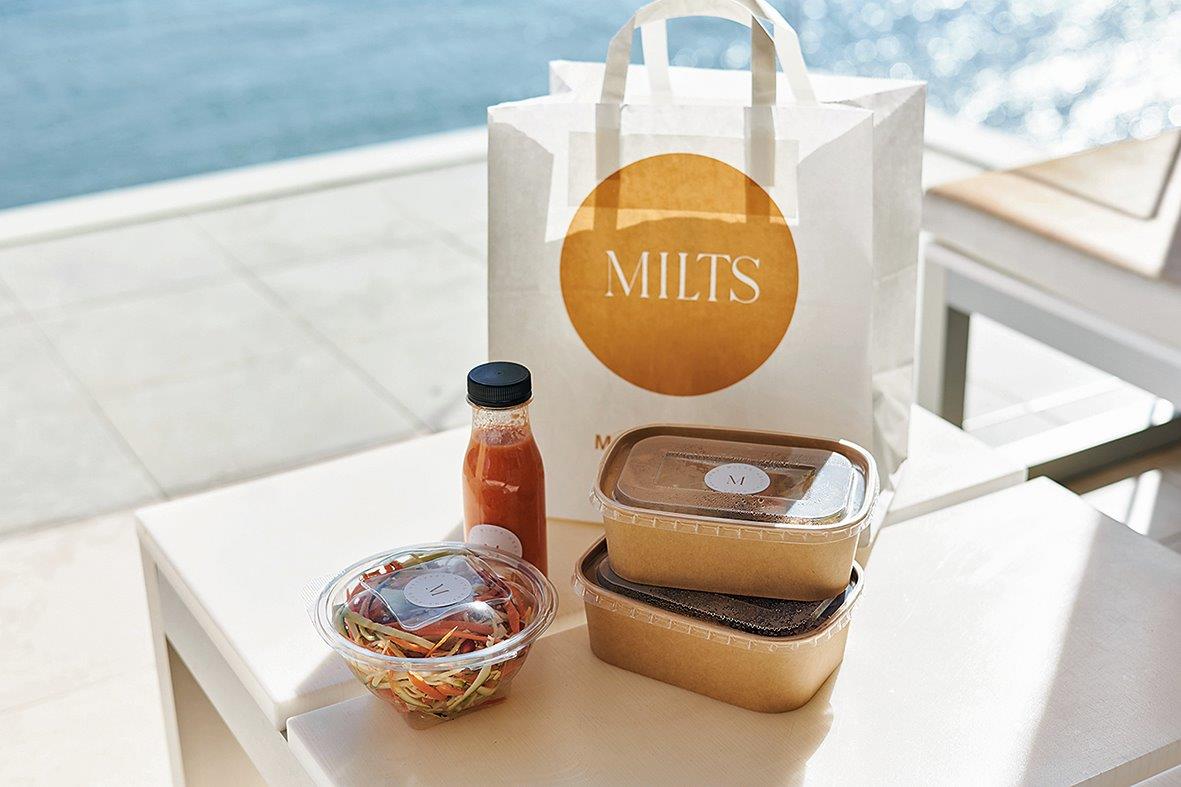 Доставка здорового питания Milts Food в Лимассоле: пакет с контейнерами и соком на террасе у моря